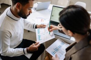 Two people at their workstation looking over Marketing Attribution data.